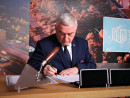 Siedzac-przy-stole-Andrzej-Betkowski-podpisuje-akt-erekcyjny