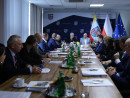 Uczestnicy spotkania siedzą przy stołach 